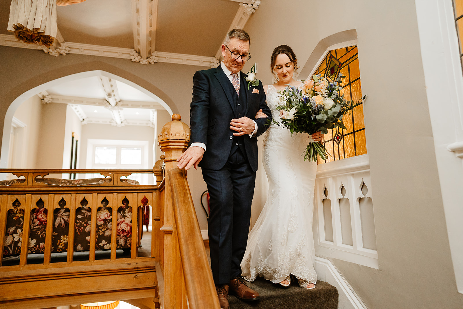 Bride and father walking down stairs