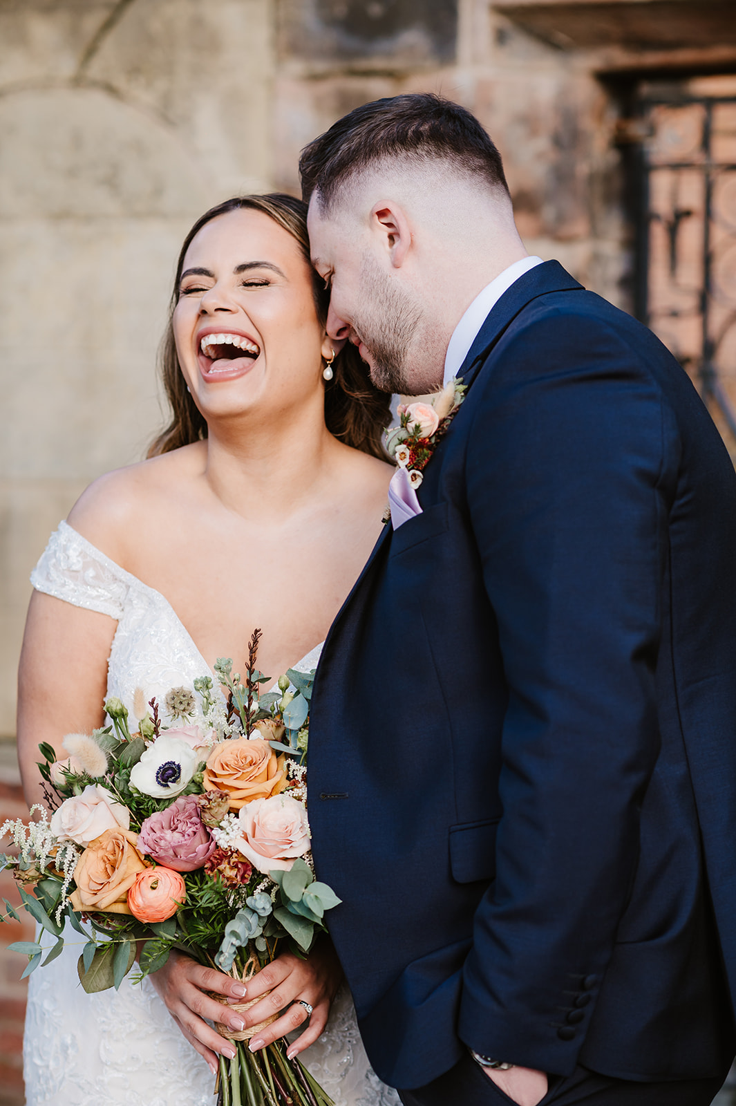 Bride laughing with groom outside