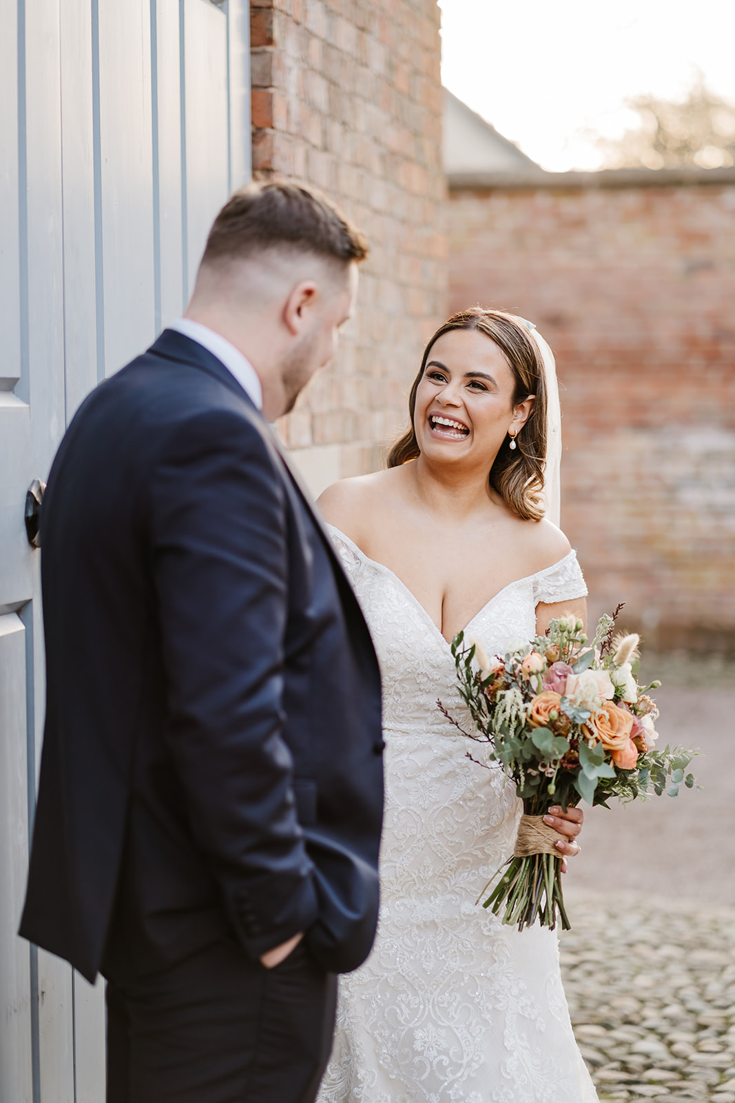 Bride and groom laughing by door