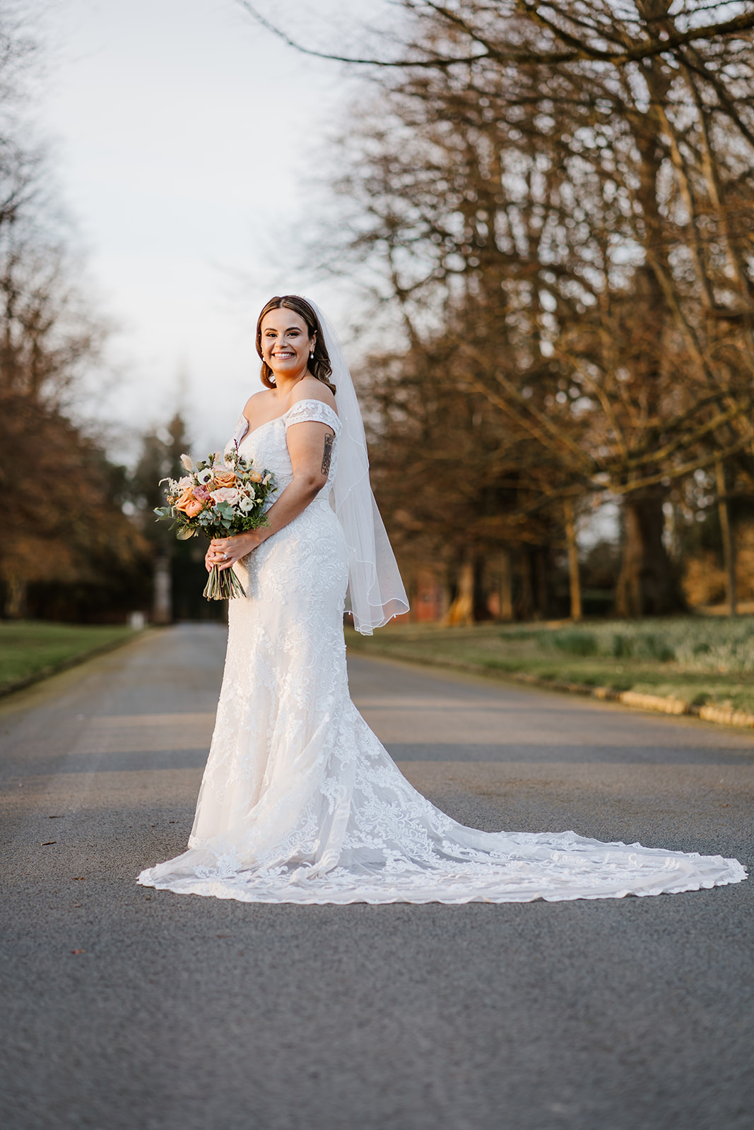 Bride posing on drive of stately home
