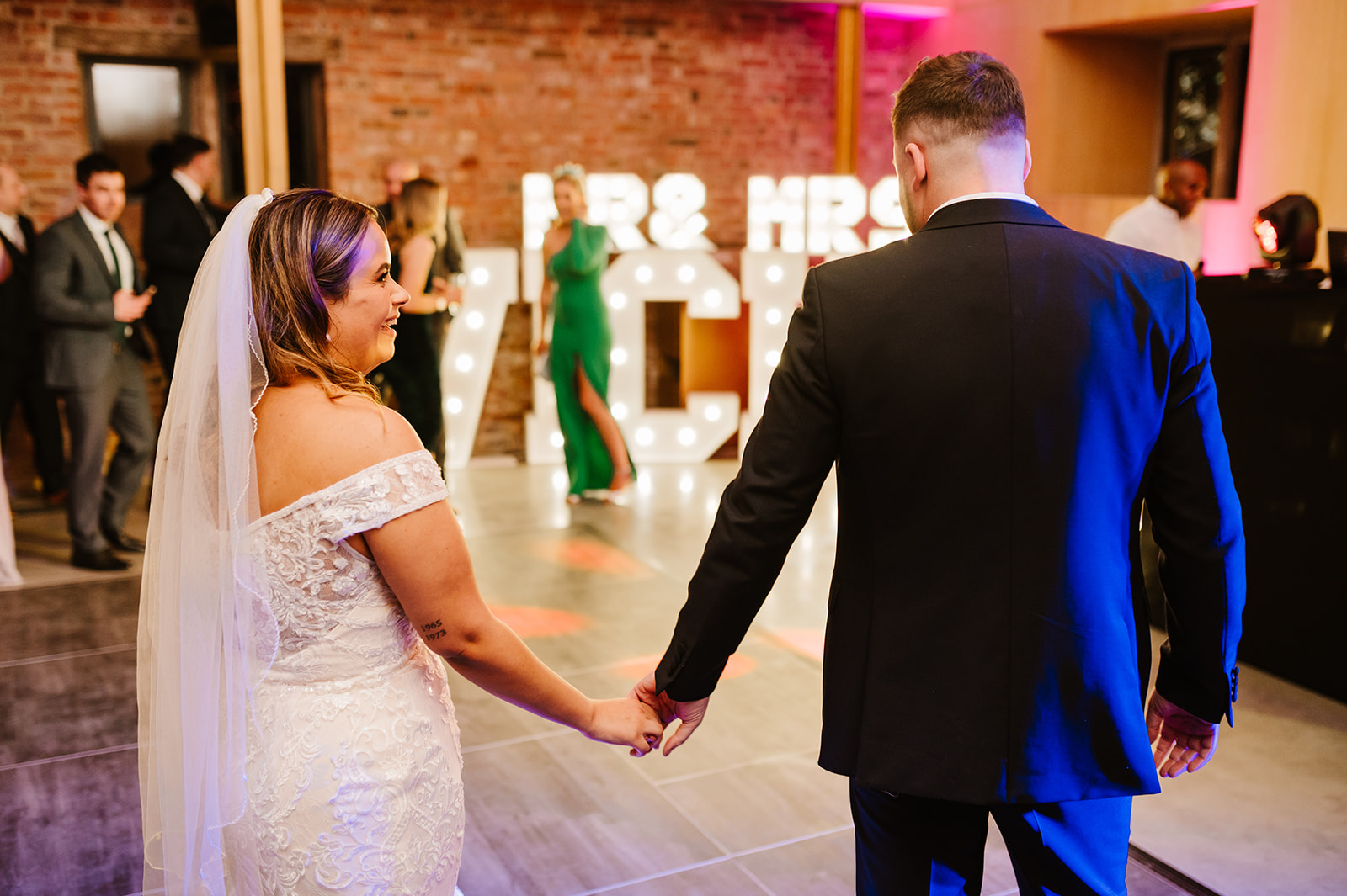 Bride and groom walking onto dancefloor