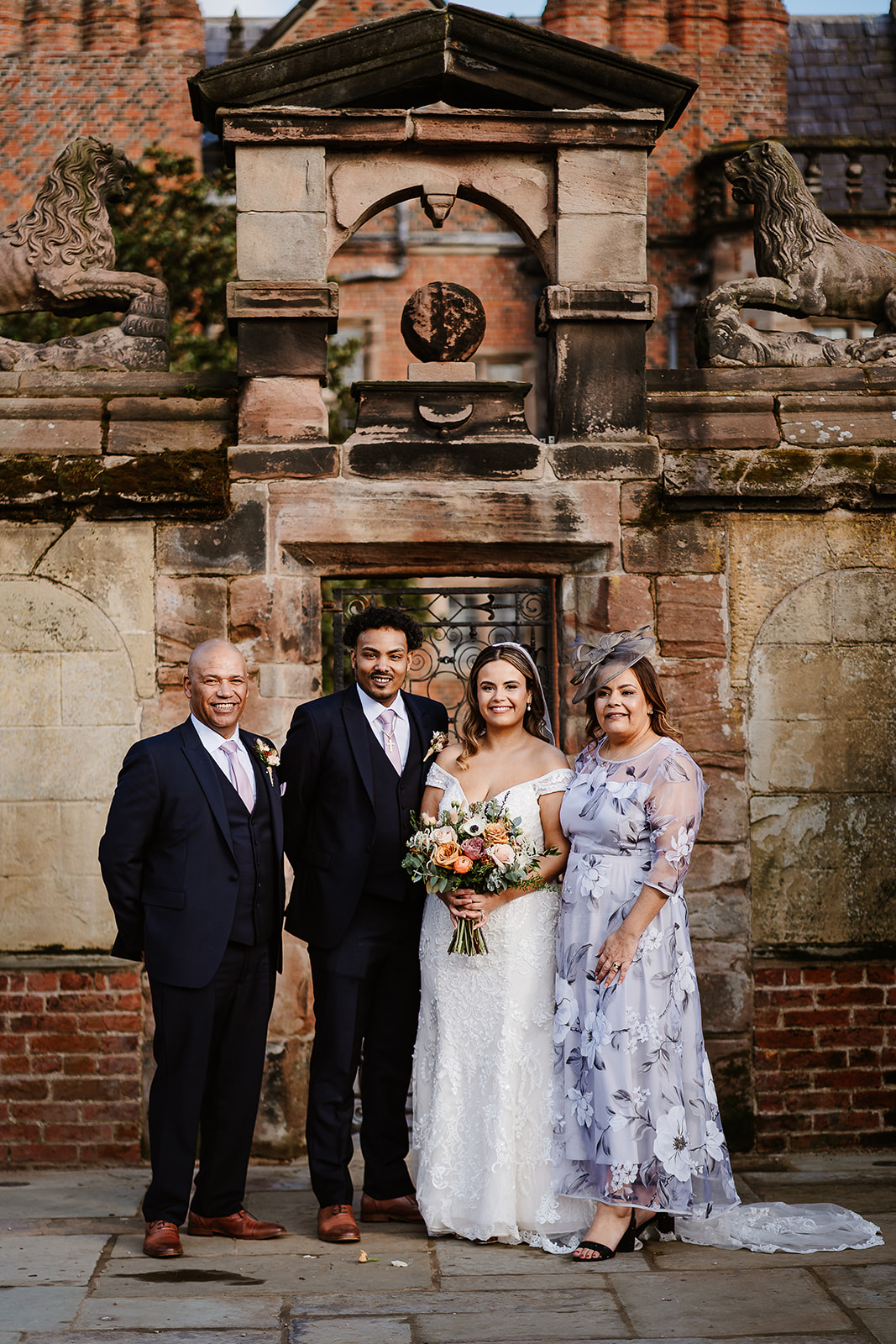 Bride and family pose in front of ornate gate