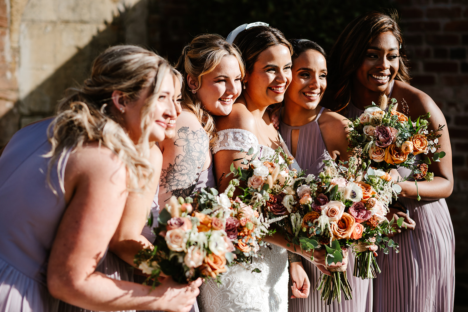 Bridesmaids posing with bouquets from side angle