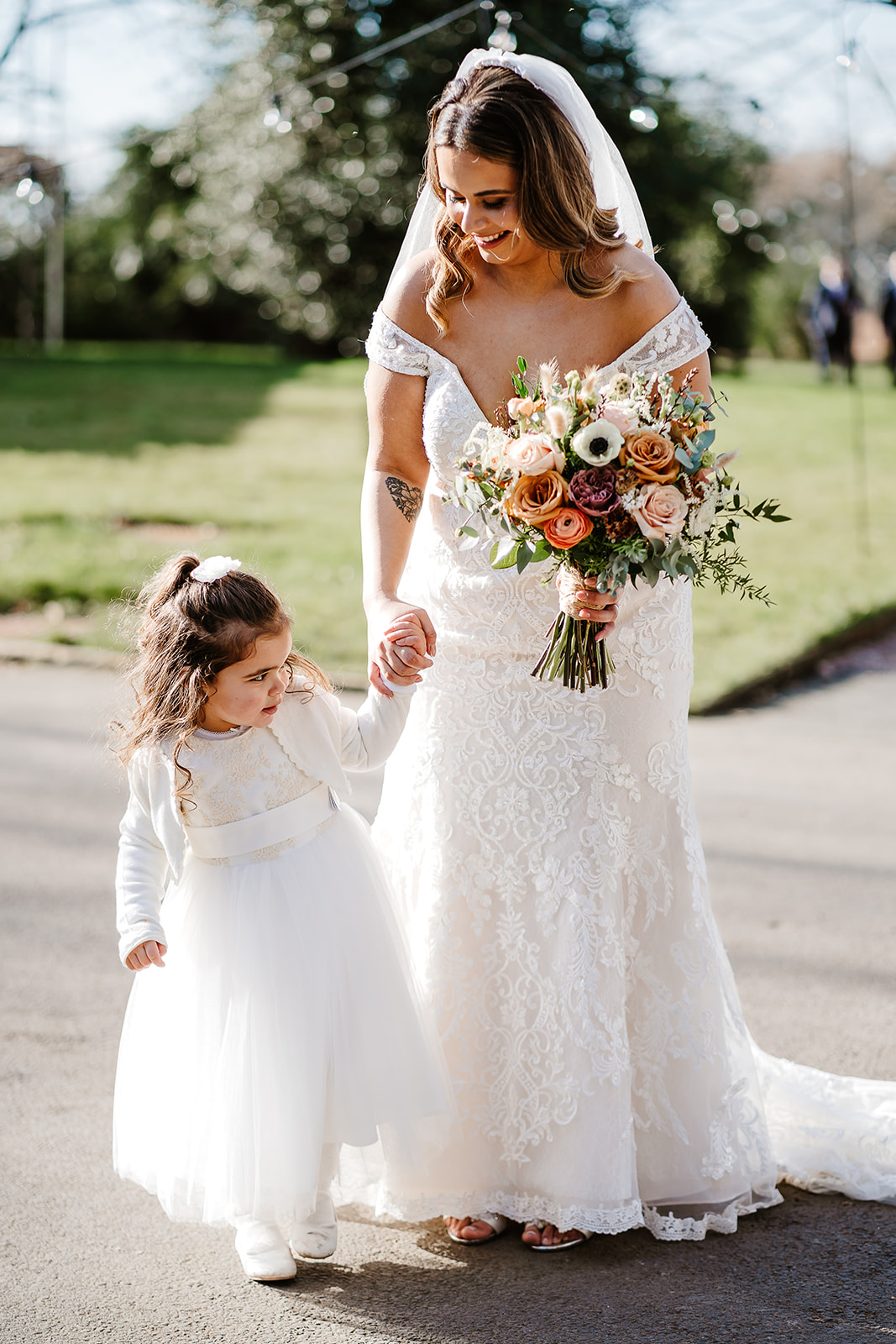 Bride holding hand of flower girl