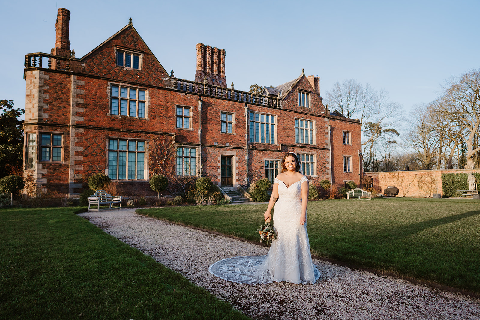 Bride posing in front of Dorfold Hall in evening sun