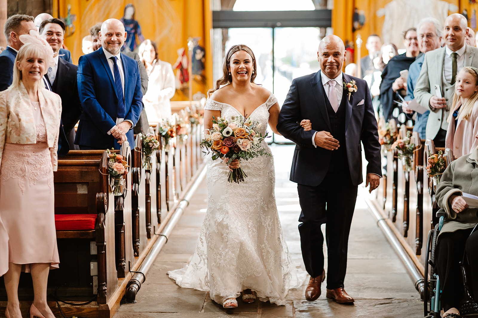 Bride and father walking down aisle in church